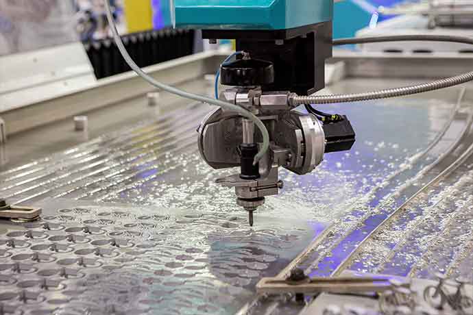 CNC water jet cutting machine precisely shaping metal with high-pressure stream in industrial setting
