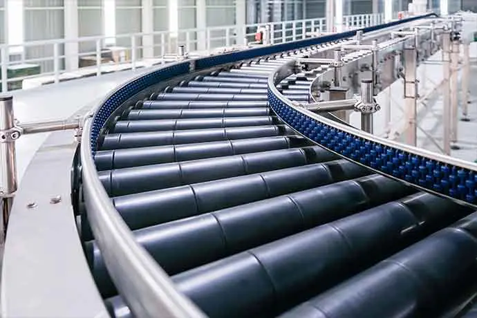 Close-up of a curved conveyor belt system in an industrial warehouse setting for efficient product transportation.