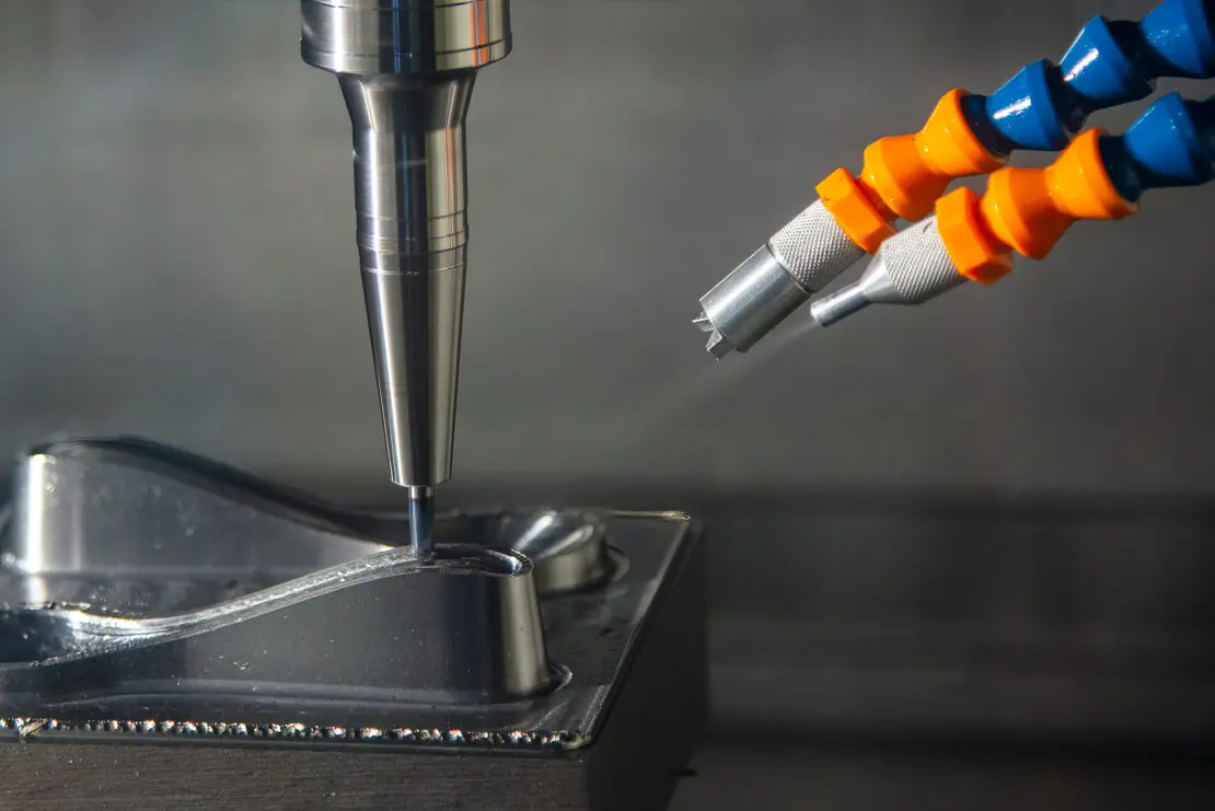 A CNC milling machine getting sprayed with an oil mist system