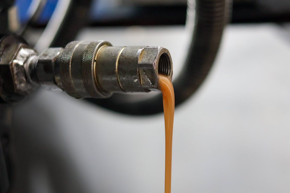 Milky brown oil lubricant releasing from a quick-release coupler