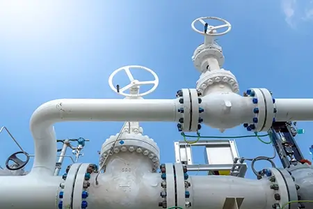 Oil and gas processing plant with pipe line valves. Industrial zone, Steel pipelines and valves blue sky. Oil pipeline valves in the oil and gas industry.